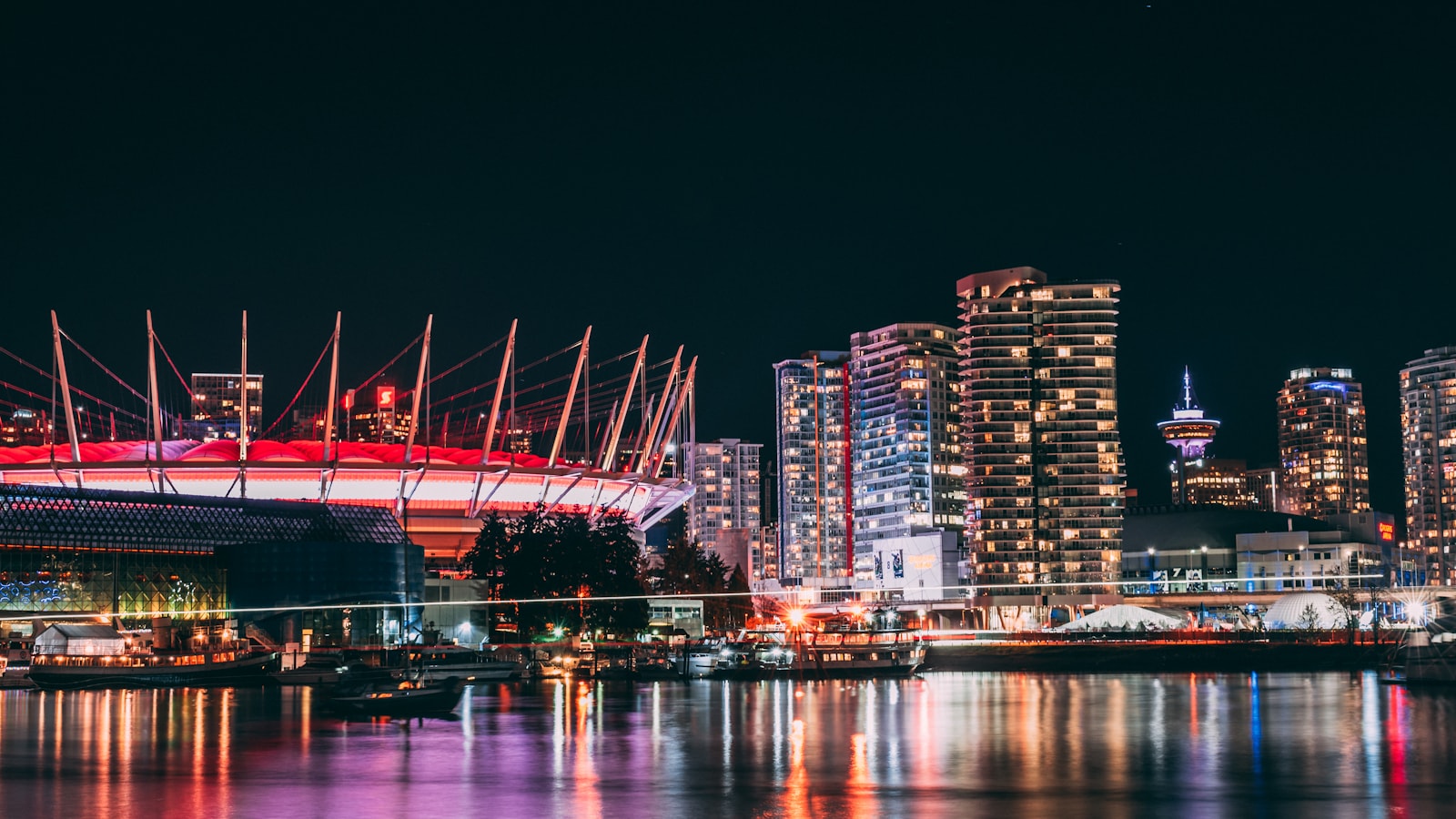 Vancouver city lights at night near BC Place for evening babysitting plans.