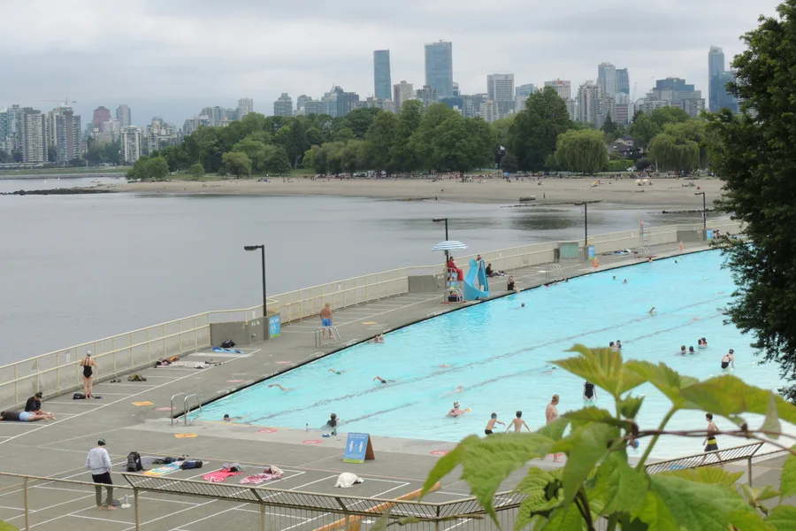 People swimming in Kitsilano Pool beside the beach during the day