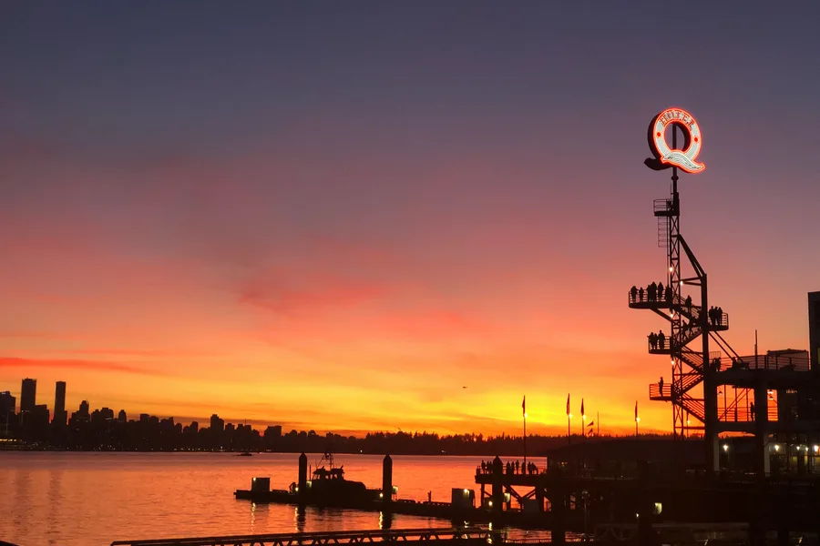 Ship silhouette on the water near Lonsdale Quay during sunset