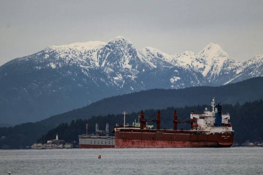 Red and white ship on the sea near snow-covered mountains