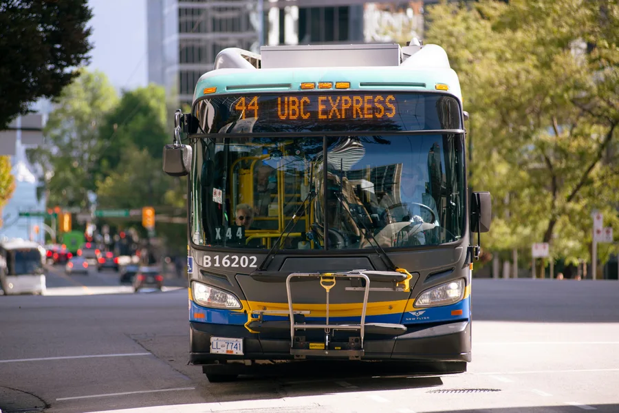 Bus driving along a Vancouver street beside tall buildings