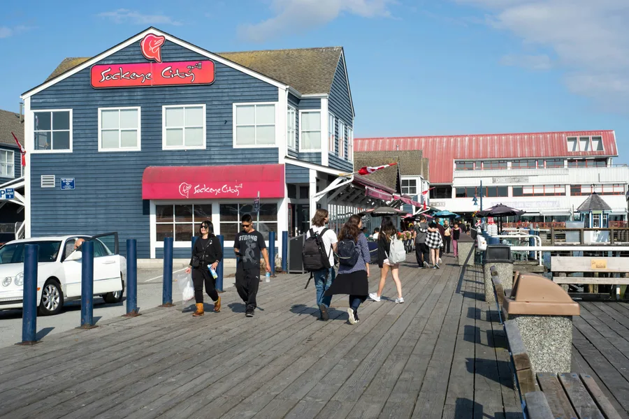 People walking along a wooden dock in Steveston during the day