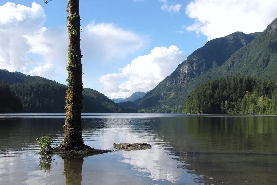 Buntzen Lake with mountain reflections and forested shoreline