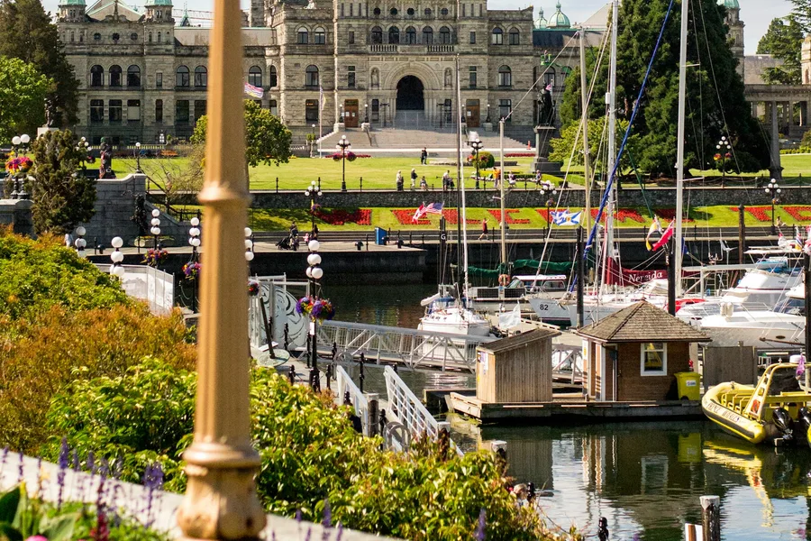 White and blue boat docked near buildings in Victoria