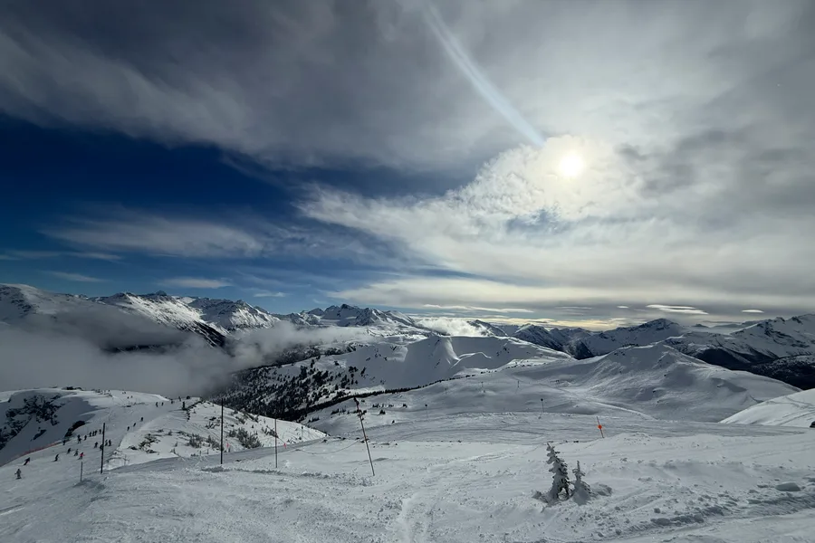 Snow-covered Whistler mountain peaks and ski runs under a bright winter sky