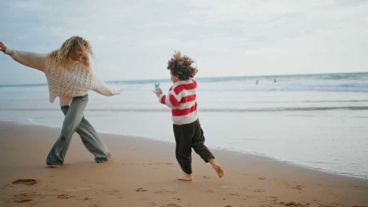 A Sunhouse caregiver and child playing together on a beach.
