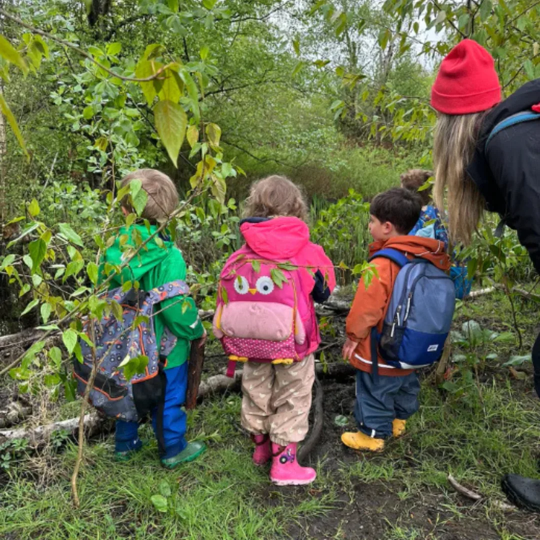 Children exploring a forest path with a Sunhouse Outdoor Academy educator.